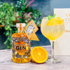 A Boothstown Orange Gin and tonic in a glass next to a bottle of Boothstown Orange gin