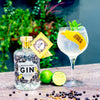 A Boothstown Dry Gin and tonic in a glass next to a bottle of Boothstown Dry gin